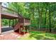 Multi-level deck overlooking a spacious yard with green grass and a wooden fence that backs up to a wooded area at 6016 Graburns Ford Dr, Charlotte, NC 28269
