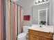 Bathroom features a vanity and shower with colorful striped curtain at 6016 Graburns Ford Dr, Charlotte, NC 28269