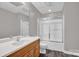 Bathroom with a wood vanity, sink, toilet, shower and tub with sliding glass doors at 6016 Graburns Ford Dr, Charlotte, NC 28269