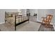 This cozy bedroom features a metal frame bed, rocking chair, and a glimpse into the workout room at 6016 Graburns Ford Dr, Charlotte, NC 28269