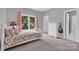 Bright bedroom features a window with backyard views, floral bedding, and neutral paint at 6016 Graburns Ford Dr, Charlotte, NC 28269