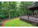 Multi-level wooden deck with green grass, wooden fence and wooded area in the background at 6016 Graburns Ford Dr, Charlotte, NC 28269