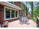 Outdoor patio furniture set on a spacious wooden deck overlooking the side yard of a brick home at 6016 Graburns Ford Dr, Charlotte, NC 28269