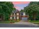Charming two-story brick home with green shutters, attached garage, and manicured lawn at sunset at 6016 Graburns Ford Dr, Charlotte, NC 28269