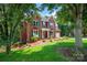 Stunning exterior view of a two-story brick home with green shutters and lush landscaping at 6016 Graburns Ford Dr, Charlotte, NC 28269