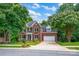 Charming two-story brick home with green shutters, attached garage, and manicured lawn at 6016 Graburns Ford Dr, Charlotte, NC 28269