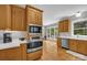 Open kitchen has wood cabinets, stainless appliances, and connects to a bright breakfast nook with outdoor views at 6016 Graburns Ford Dr, Charlotte, NC 28269