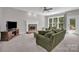 Cozy living room features a fireplace, comfortable seating, and access to the outdoor patio at 6016 Graburns Ford Dr, Charlotte, NC 28269