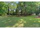 Large backyard with mature trees and a storage shed offers plenty of space to roam at 7151 Plough Dr, Mint Hill, NC 28227
