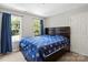 Bedroom featuring a bed with a blue comforter, two windows, and neutral-colored walls at 7151 Plough Dr, Mint Hill, NC 28227
