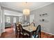 Bright dining room with hardwood floors, modern chandelier, and neutral wall color at 7151 Plough Dr, Mint Hill, NC 28227