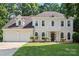 Charming traditional home with a two-car garage, manicured lawn, and covered front entrance at 7151 Plough Dr, Mint Hill, NC 28227