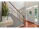 Inviting foyer with hardwood floors, staircase, and a decorative plant on the console table at 7151 Plough Dr, Mint Hill, NC 28227