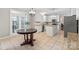 Bright eat-in kitchen with stainless appliances, granite countertops, white cabinets, and tile flooring at 7151 Plough Dr, Mint Hill, NC 28227