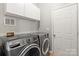 Well-lit laundry room features a washer and dryer and white cabinets for storage at 7151 Plough Dr, Mint Hill, NC 28227