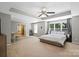 Spacious bedroom with carpet, neutral walls, ceiling fan, tray ceiling, and natural light from backyard at 7151 Plough Dr, Mint Hill, NC 28227