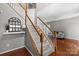 Elegant staircase with wood railing leading to the upper level and a mirror on the wall at 7151 Plough Dr, Mint Hill, NC 28227