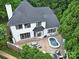 Aerial view of landscaped backyard with patio, spa, seating, and outdoor kitchen perfect for entertaining at 8016 Pemswood St, Charlotte, NC 28277