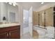 Bathroom with granite vanity and a shower-tub combination with glass enclosure at 8016 Pemswood St, Charlotte, NC 28277