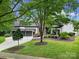 Inviting home exterior with lush landscaping, a wide driveway, and a three-car garage at 8016 Pemswood St, Charlotte, NC 28277