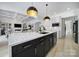 Open kitchen with black island, granite countertops, and view to the living room at 8016 Pemswood St, Charlotte, NC 28277