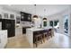 Modern kitchen with large black island, stainless steel appliances, and wooden stools at 8016 Pemswood St, Charlotte, NC 28277
