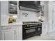 Gourmet kitchen with white cabinetry, stainless steel appliances, and gas range at 8016 Pemswood St, Charlotte, NC 28277
