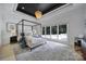 Spacious bedroom with four-poster bed, large windows, and neutral decor at 8016 Pemswood St, Charlotte, NC 28277
