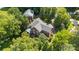 A high angle, full view of a brick home with mature trees, deck, and lush landscaping at 8900 Cumbria Ct, Huntersville, NC 28078
