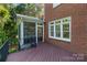 Back porch with stairs, door to sunroom, and view of brick home at 8900 Cumbria Ct, Huntersville, NC 28078