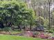 A tranquil backyard with a bench nestled amongst trees and garden at 8900 Cumbria Ct, Huntersville, NC 28078