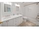 Bright bathroom featuring double sinks, a shower with a tub, and ample lighting at 8900 Cumbria Ct, Huntersville, NC 28078