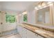 Bright bathroom featuring double sinks, granite counters, glass shower, and outdoor views at 8900 Cumbria Ct, Huntersville, NC 28078