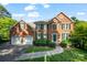 Beautiful two-story brick home featuring a well-manicured lawn and a two-car garage at 8900 Cumbria Ct, Huntersville, NC 28078