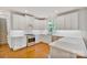 Modern kitchen features white cabinets, stainless steel appliances, and sleek countertops with hardwood floors at 8900 Cumbria Ct, Huntersville, NC 28078