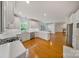 Open-concept kitchen with white cabinets, stainless steel appliances, and hardwood floors overlooking the living area at 8900 Cumbria Ct, Huntersville, NC 28078