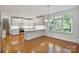Gourmet kitchen with white cabinets, stainless steel appliances, hardwood floors, and a breakfast bar at 8900 Cumbria Ct, Huntersville, NC 28078