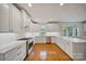 Well-lit kitchen with white cabinets, stainless steel appliances, subway tile backsplash, and hardwood floors at 8900 Cumbria Ct, Huntersville, NC 28078