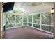 Bright sunroom featuring a ceiling fan, dark wood floor, and large windows overlooking green foliage at 8900 Cumbria Ct, Huntersville, NC 28078