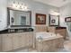 Relaxing bathroom showcases a soaking tub, travertine tile, and dual vanities at 9730 White Frost Rd, Charlotte, NC 28277