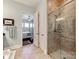Elegant bathroom showcasing travertine floors, a glass shower, and a bedroom view at 9730 White Frost Rd, Charlotte, NC 28277