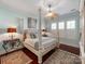 Comfortable bedroom with a four-poster bed, wood floors, and plantation shutters at 9730 White Frost Rd, Charlotte, NC 28277