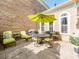 Backyard patio with a dining set, umbrella, grill, and surrounded by a brick wall and greenery at 9730 White Frost Rd, Charlotte, NC 28277