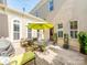 Backyard patio with a dining set, umbrella, grill, and surrounded by a brick wall and greenery at 9730 White Frost Rd, Charlotte, NC 28277