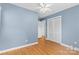 Serene bedroom with blue walls, hardwood floors, a ceiling fan, and closet with louvered doors at 1024 Regency Dr, Charlotte, NC 28211