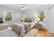Cozy bedroom featuring neutral decor, two windows and hardwood floors at 1024 Regency Dr, Charlotte, NC 28211