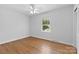 Bright bedroom features hardwood floors, white walls, a ceiling fan, and a window view at 1024 Regency Dr, Charlotte, NC 28211