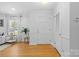 Inviting foyer with hardwood floors, paneled walls, natural lighting, and a view into the living room at 1024 Regency Dr, Charlotte, NC 28211
