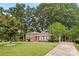 Traditional brick home boasts lush landscaping and a long driveway leading to a welcoming entrance at 1024 Regency Dr, Charlotte, NC 28211