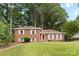 Charming brick home featuring pristine landscaping, symmetrical design, and bright white shutters at 1024 Regency Dr, Charlotte, NC 28211